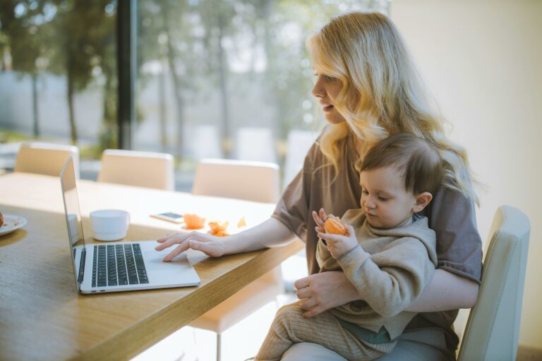 mom with laptop holding baby on lap