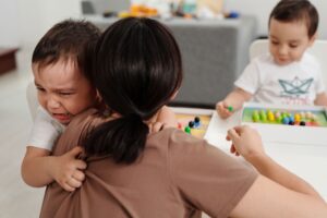 boy hugging a woman while crying