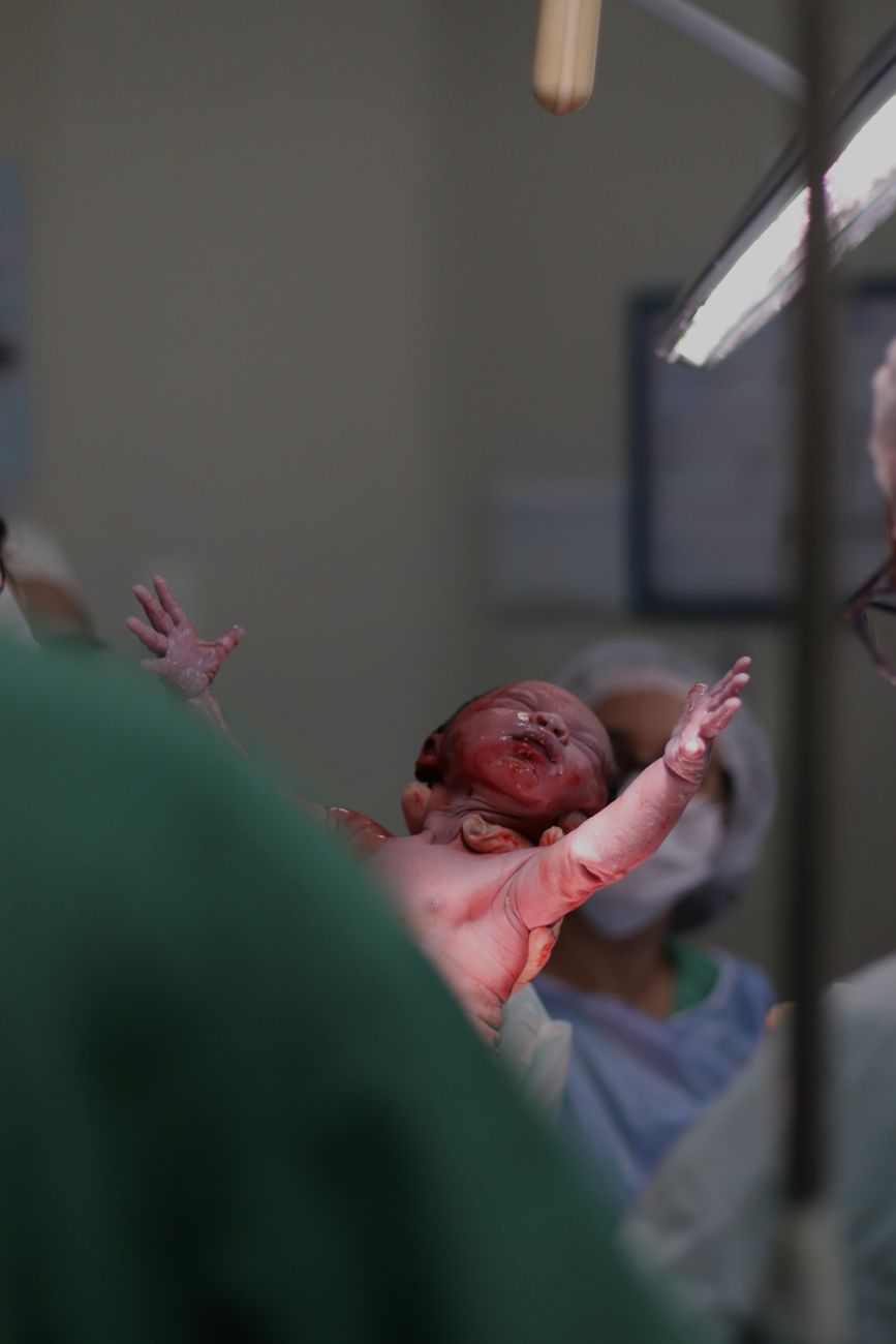 a baby is being held up by a doctor